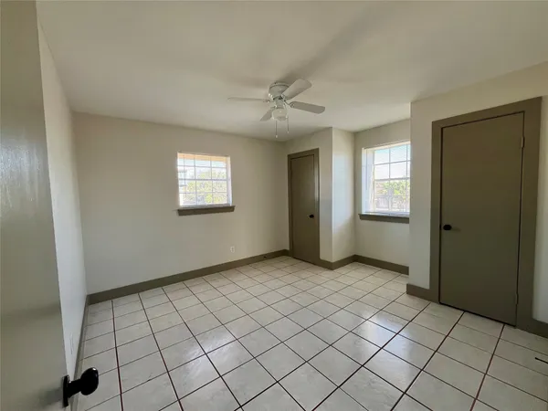 an empty room with windows and closet