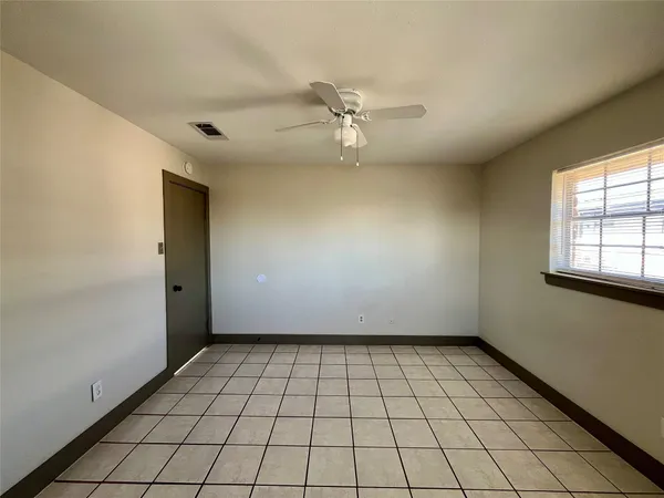 an empty room with windows and ceiling fan