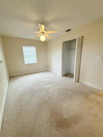 an empty room with a window and a chandelier