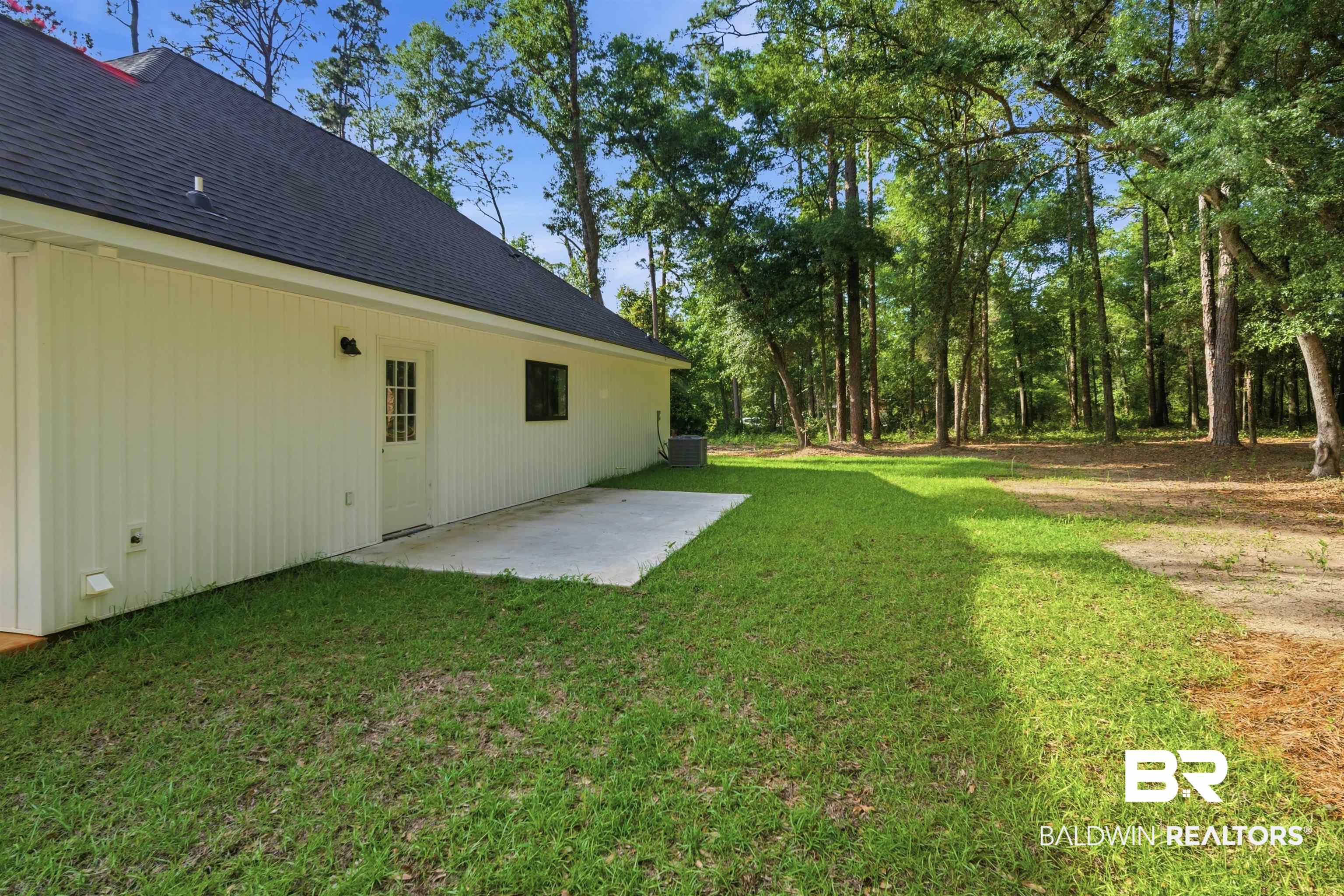 14128 Jackson Lane Foley, AL 36535 - Photo 4 of 36 Expansive green lawn bordering a concrete patio