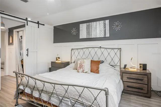 a bedroom with bed and wooden floor
