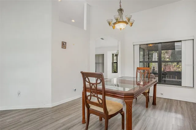 a dining room with furniture a chandelier and wooden floor