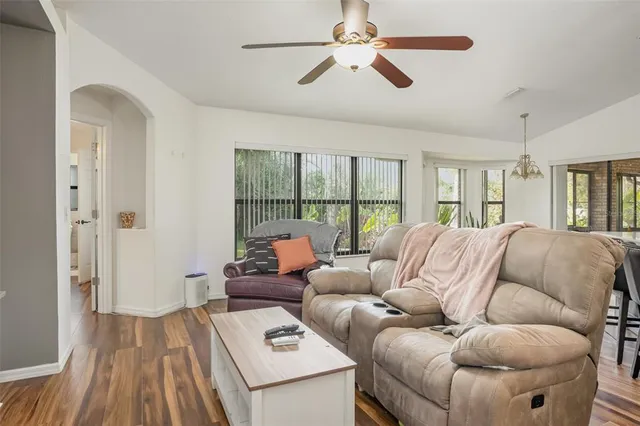 a living room with furniture a ceiling fan and a rug