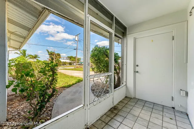 an empty room with windows and ceiling fan
