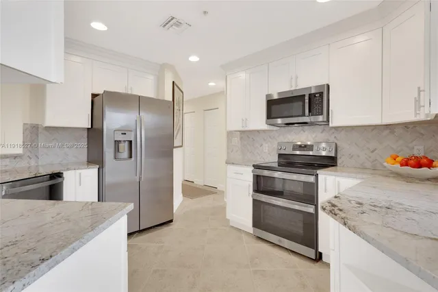 a kitchen with stainless steel appliances granite countertop a refrigerator stove and microwave