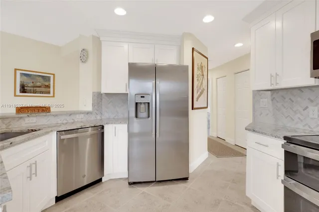 a kitchen with stainless steel appliances granite countertop a refrigerator and a stove