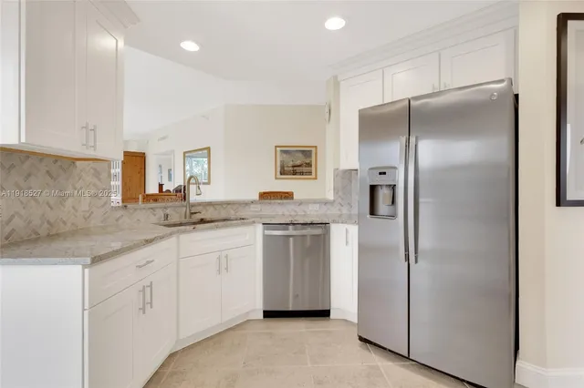 a kitchen with stainless steel appliances granite countertop a refrigerator and a sink