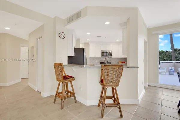a kitchen with a white cabinets and window