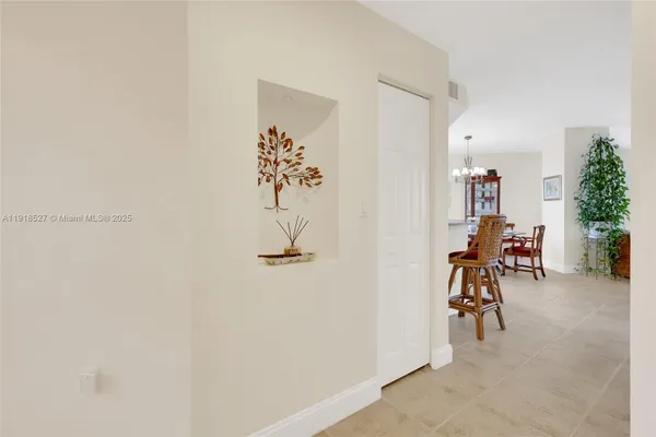 a view of a hallway with a table and chairs