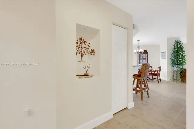 a view of a hallway with a table and chairs