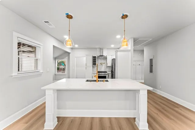 a kitchen with kitchen island a sink stove and wooden floor
