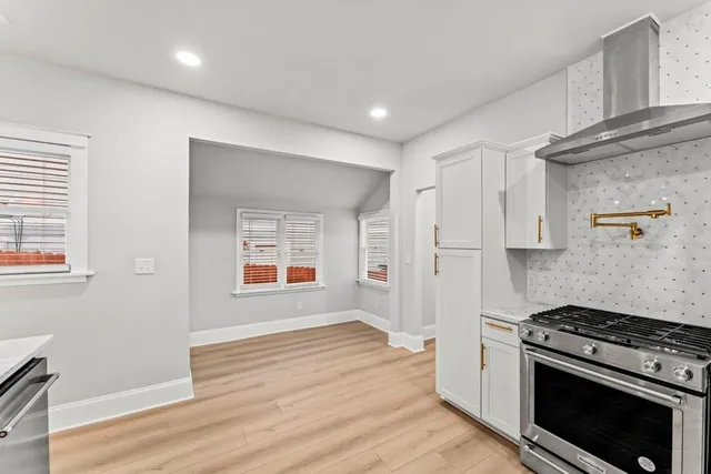 a kitchen with stainless steel appliances granite countertop a refrigerator and a stove