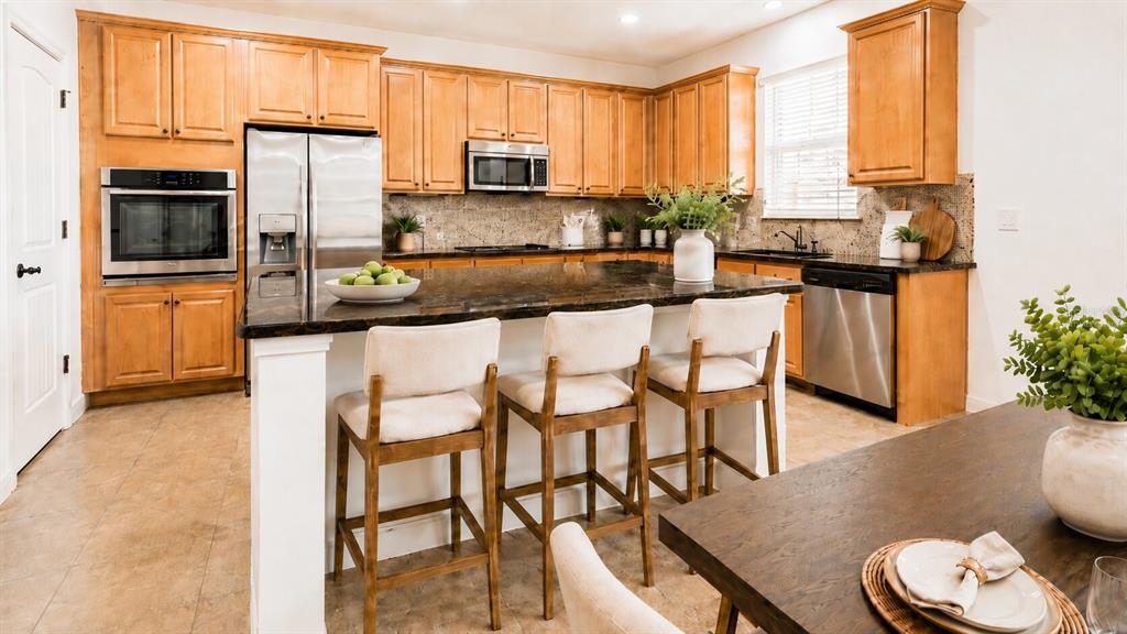 8531 Geddes Loop Orlando, FL 32836 - Photo 6 of 20 a kitchen with stainless steel appliances granite countertop a stove top oven a sink a refrigerator with a dining table and chairs