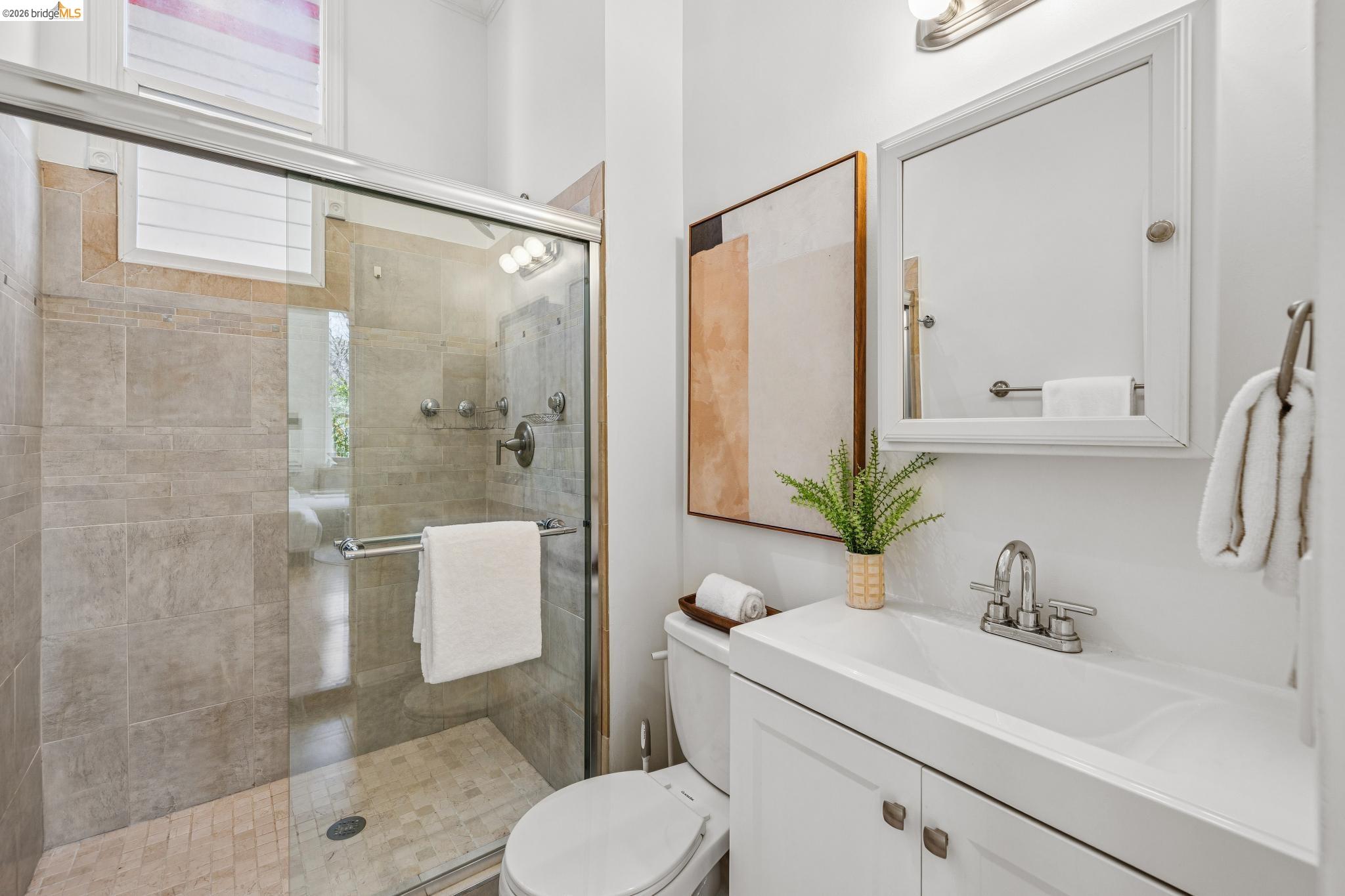 1655 12th Street Oakland, CA 94607 - Photo 21 of 51 a bathroom with a sink a mirror a toilet and shower