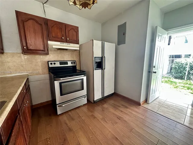 a kitchen with granite countertop wooden floors and stainless steel appliances