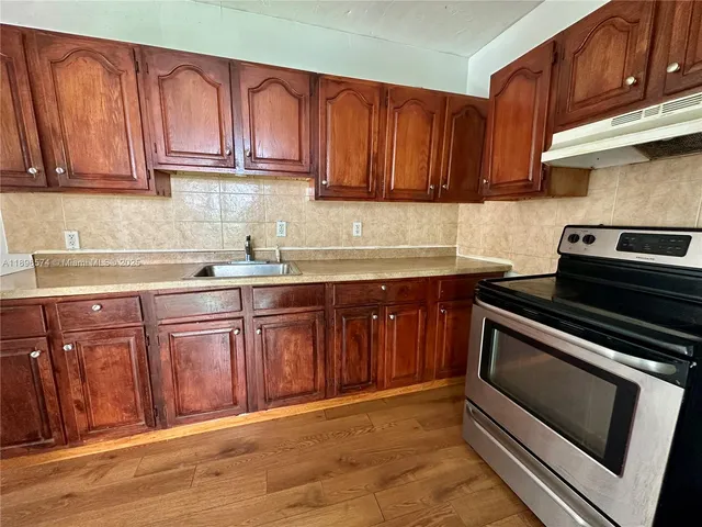 a kitchen with sink cabinets and stainless steel appliances
