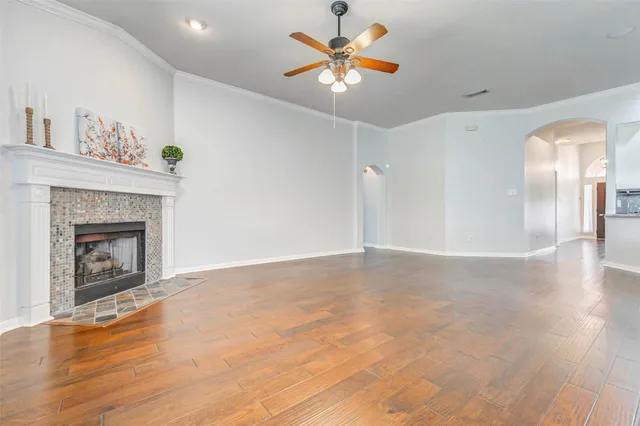 a view of an empty room with a fireplace and a chandelier fan