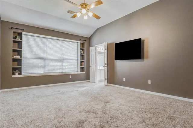 a view of an empty room with a window and a flat screen tv