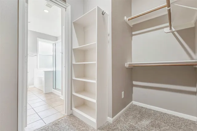 a view of walk in closet with empty racks