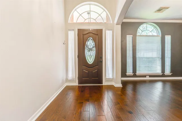 an empty room with wooden floor and window