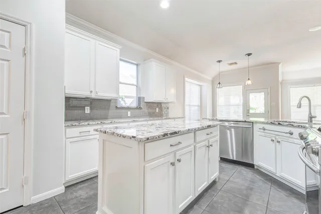 a kitchen with granite countertop white cabinets and white appliances