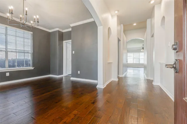 a view of a hallway with wooden floor and windows