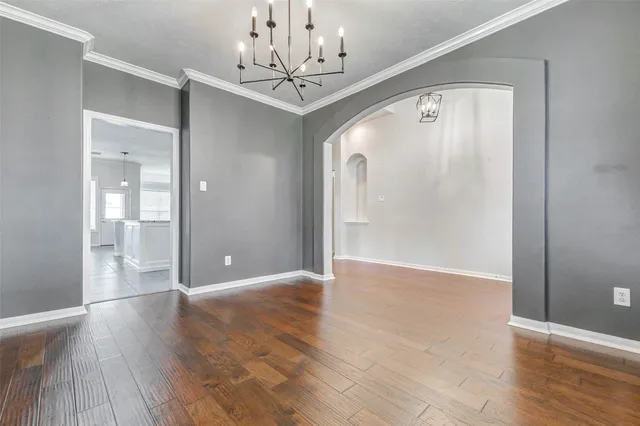 a view of a hallway with wooden floor and chandelier