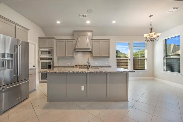 a kitchen with stainless steel appliances granite countertop a sink a stove and a refrigerator