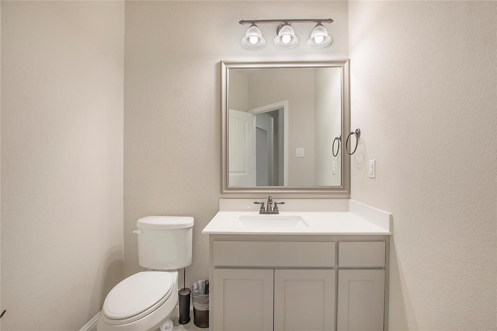 2811 Diamond Ridge Drive Arlington, TX 76001 - Photo 23 of 35 a bathroom with a toilet sink vanity and mirror