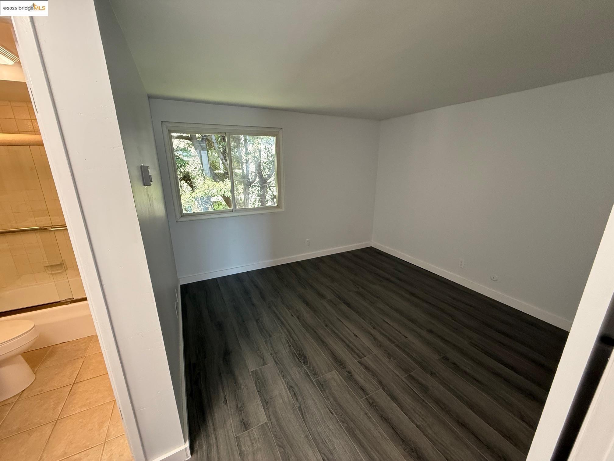4057 Brant Street, Unit 8 San Diego, CA 92103 - Photo 12 of 17 a view of an empty room with wooden floor and a window