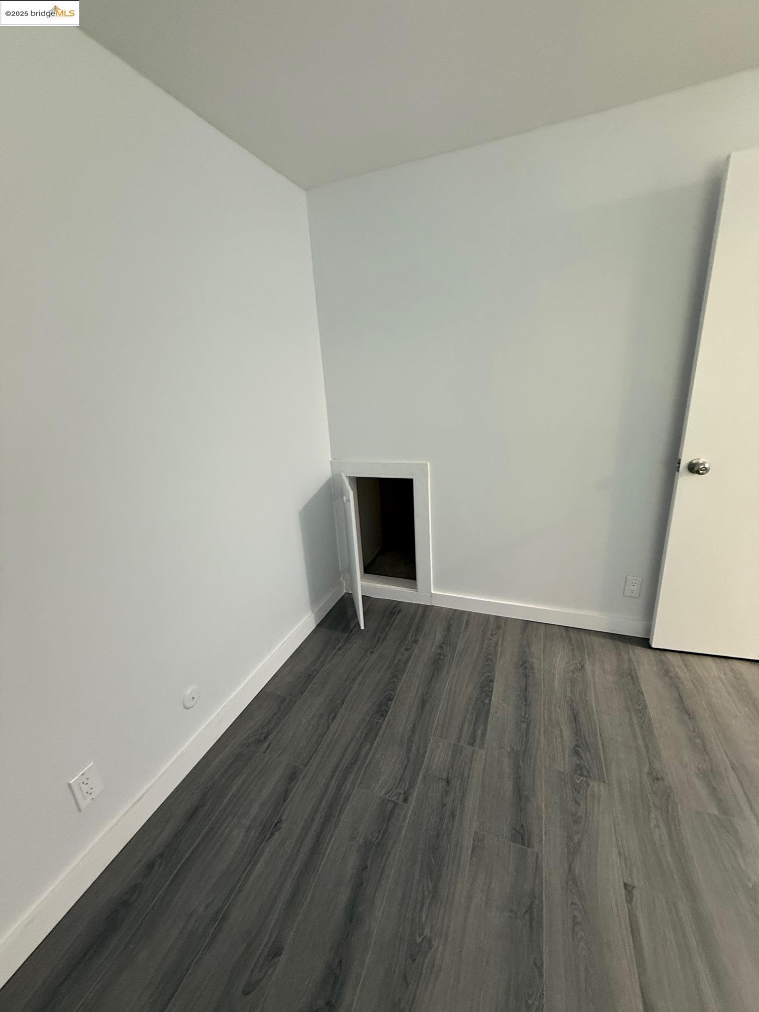 4057 Brant Street, Unit 8 San Diego, CA 92103 - Photo 14 of 17 a view of an empty room with wooden floor and a window