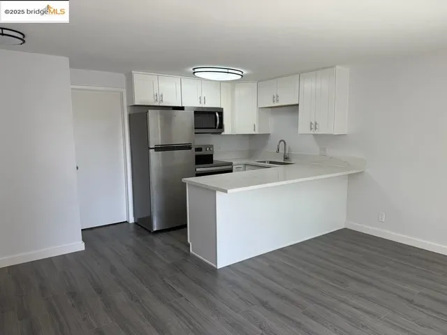 a kitchen with a refrigerator sink and cabinets
