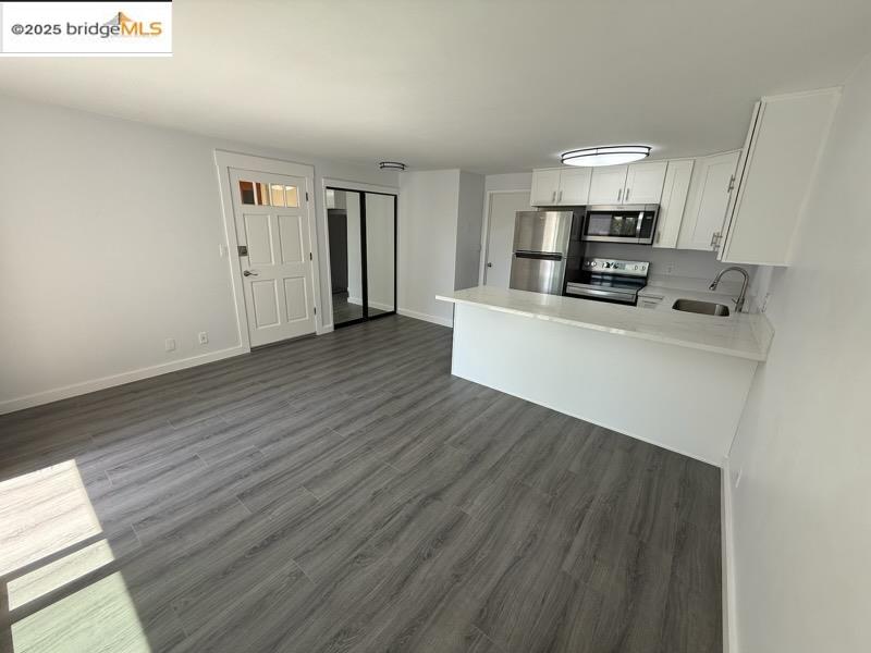 4057 Brant Street, Unit 8 San Diego, CA 92103 - Photo 5 of 17 a living room with stainless steel appliances a wooden floor a large window and a fireplace