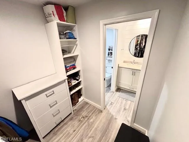 a view of walk in closet with clothes and shoes