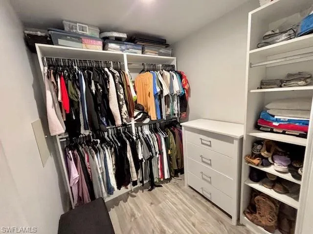 a view of walk in closet with clothes and shoes