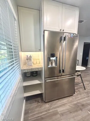 a kitchen with kitchen island a counter top space wooden floor and stainless steel appliances