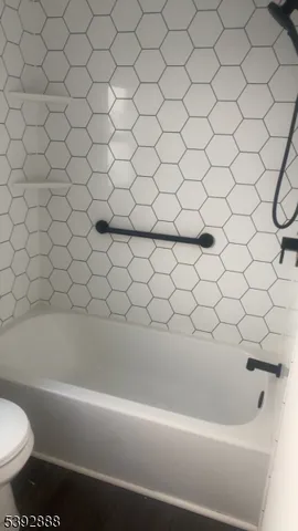 a bathroom with a white bathtub and a toilet