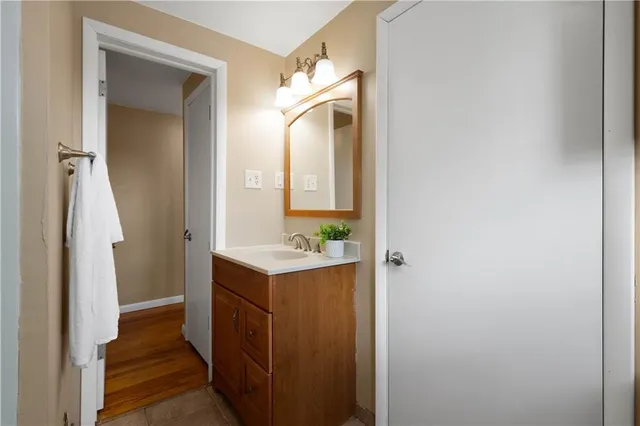 a bathroom with a sink and mirror with shower