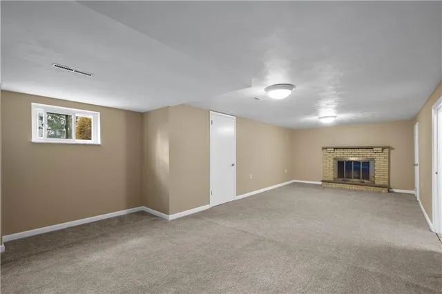 a view of empty room with a fireplace