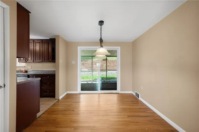 a view of a kitchen with a stove wooden cabinets and a large window