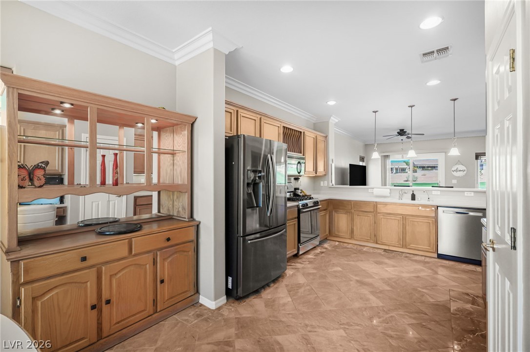 2738 Grand Forks Road Henderson, NV 89052 - Photo 10 of 52 Polished tile flooring and classic crown molding frame this spacious kitchen and service area.