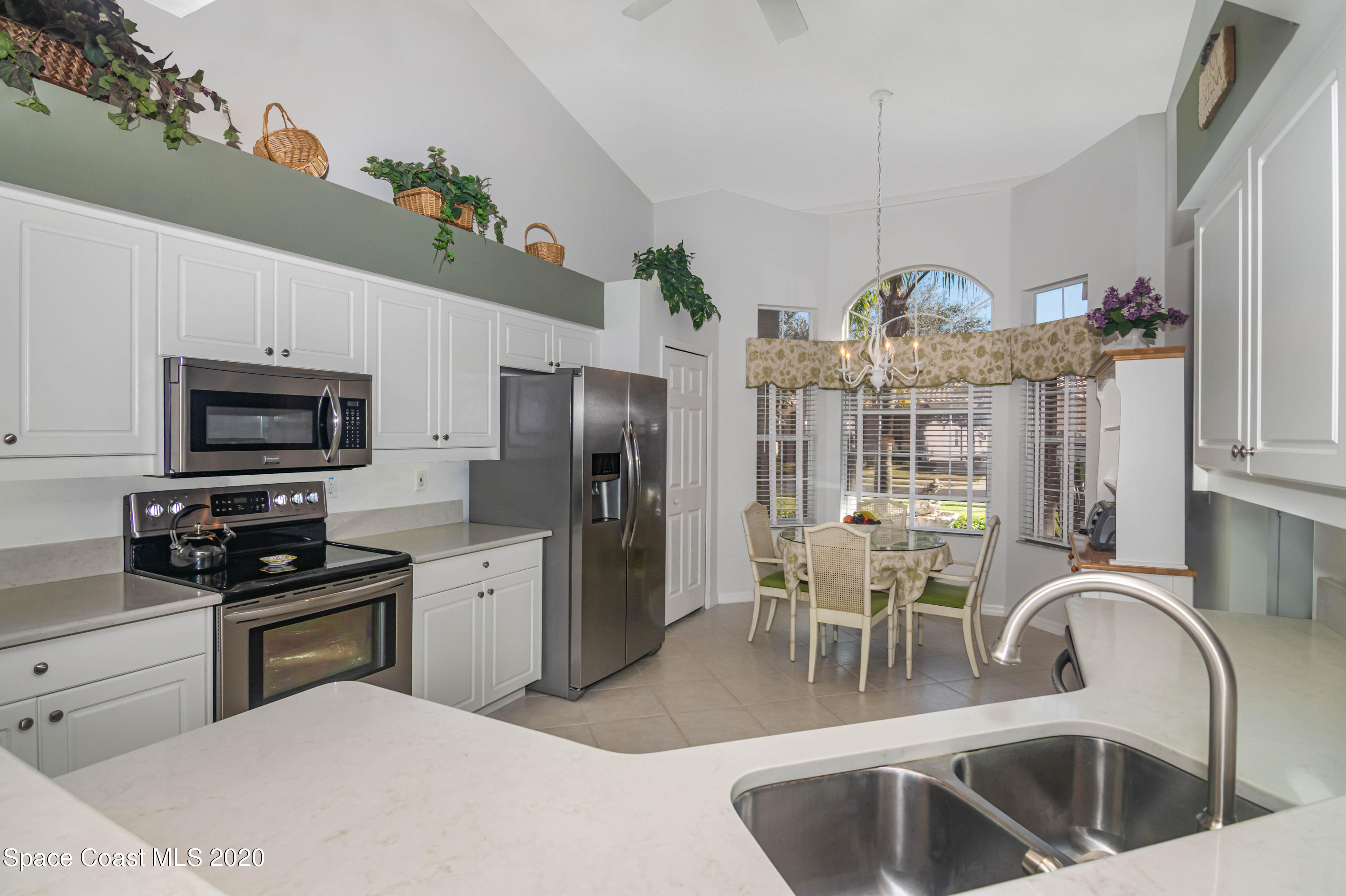 421 Shell Cove Drive Melbourne, FL 32940 - Photo 11 of 23 a kitchen with refrigerator and microwave