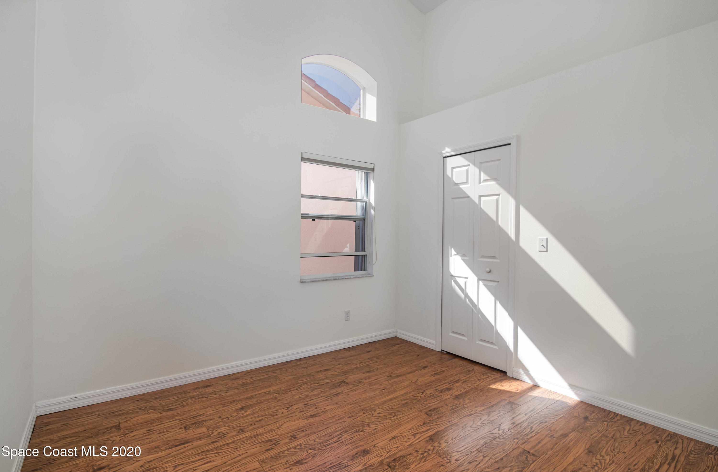 421 Shell Cove Drive Melbourne, FL 32940 - Photo 20 of 23 a view of an empty room with wooden floor and a window