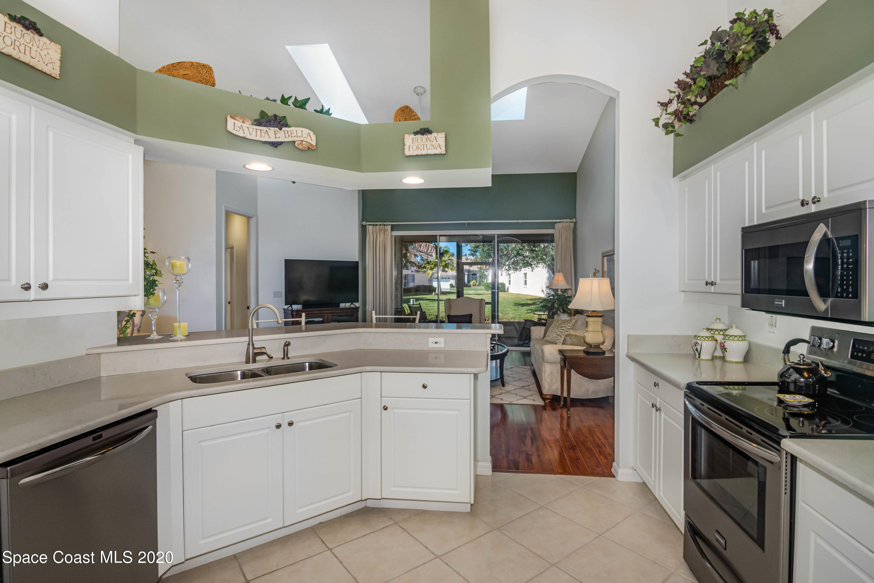 421 Shell Cove Drive Melbourne, FL 32940 - Photo 9 of 23 a kitchen with a sink dishwasher stove and white cabinets