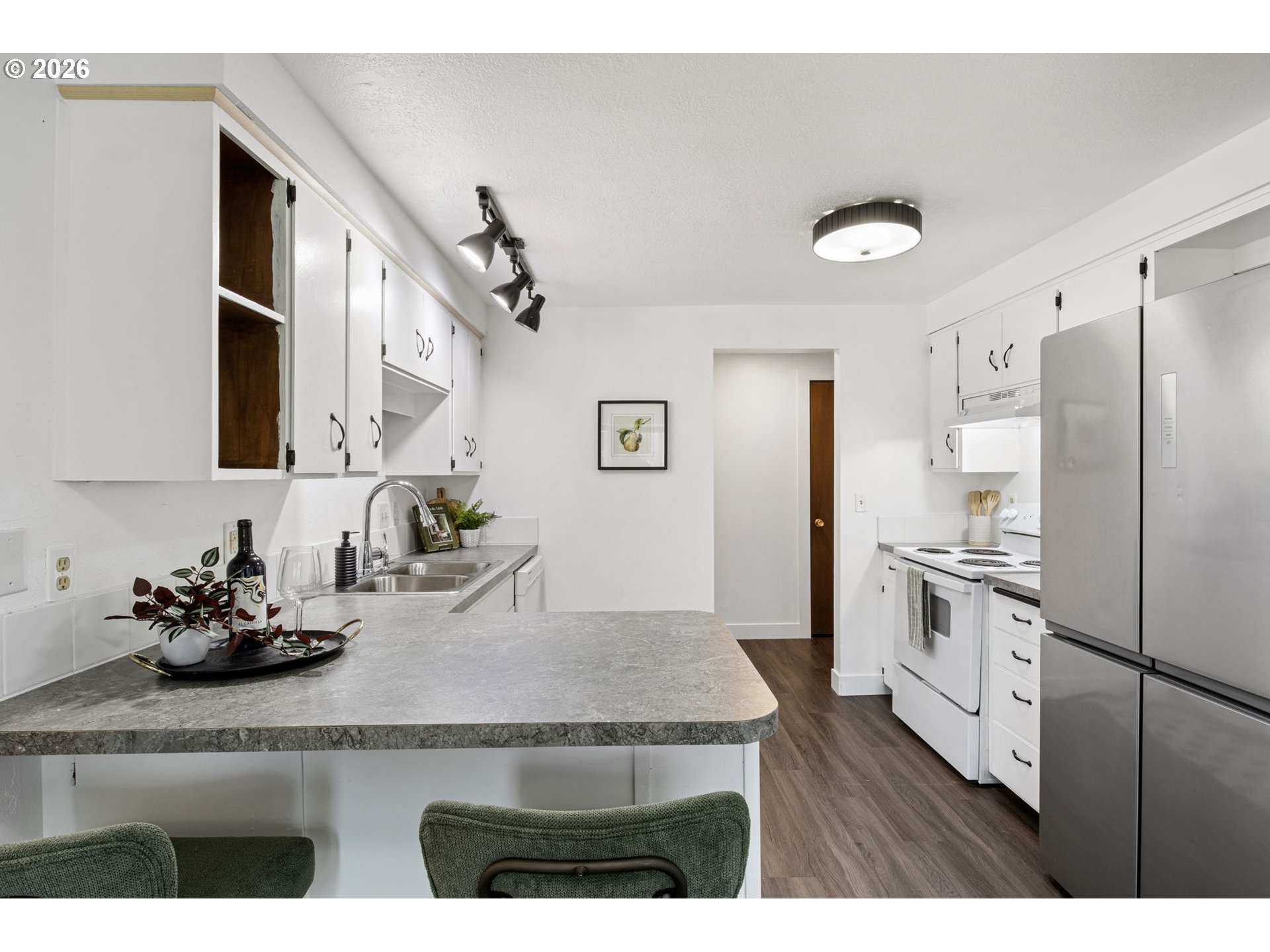 1885 Churchill Street Eugene, OR 97405 - Photo 7 of 45 a kitchen with stainless steel appliances granite countertop a refrigerator a sink dishwasher and white cabinets with wooden floor