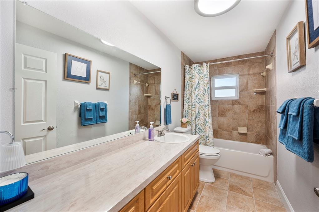 1106 Lakewood Road Lakeland, FL 33805 - Photo 17 of 27 a bathroom with a granite countertop sink a toilet a mirror a bathtub and shower