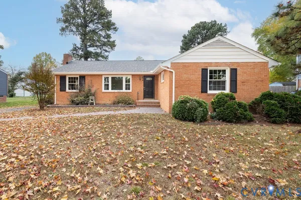 a front view of a house with yard and trees