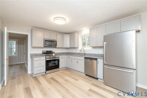 a kitchen with a refrigerator stove top oven and sink