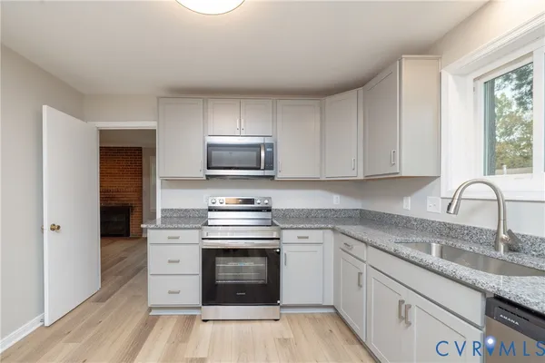 a kitchen with stainless steel appliances granite countertop a stove sink and cabinets