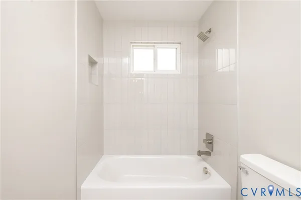 a white bath tub sitting next to a white toilet